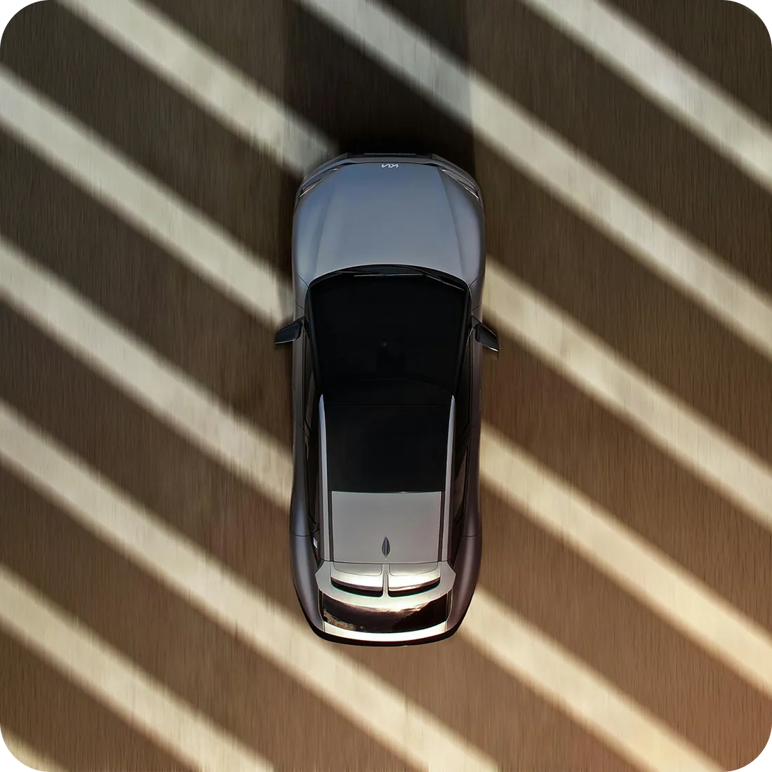 Overhead view of a car parked in striped sunlight