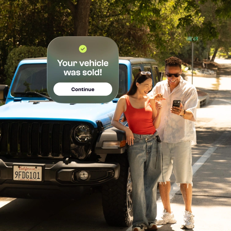 Pareja celebrando junto a su auto después de venderlo